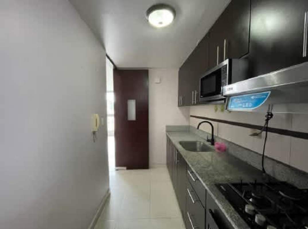 Modern narrow kitchen with granite counters, microwave, and gas stove PH McGregor Heights Panama