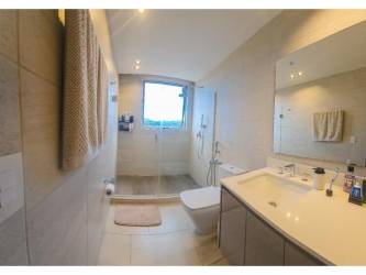 Bathroom with glass-enclosed shower, modern vanity and upscale finishes in PH Canal View