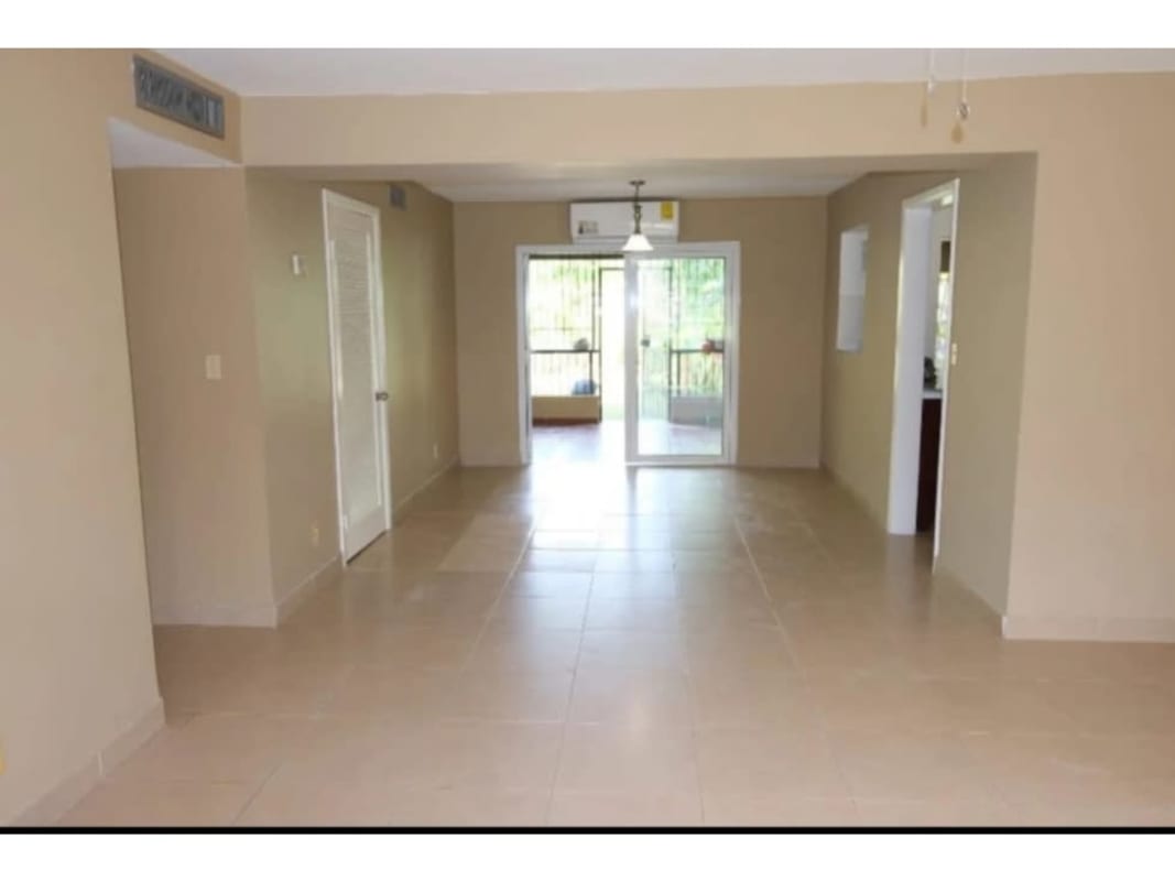 Empty tiled living room with large windows, ceiling fan, blinds and balcony access in PH Residencial Clayton Panama City