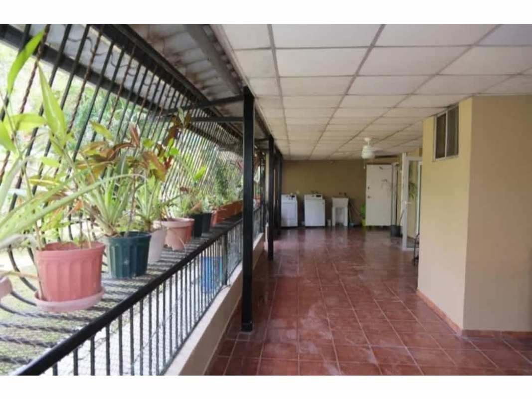 Covered laundry space with tiled floors, washing machines and security bars in PH Residencial Clayton Panama