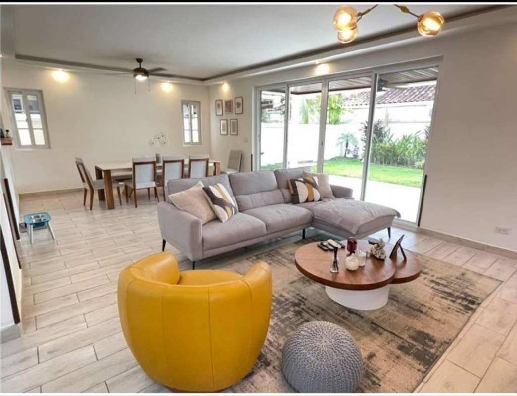 Open-design living dining room with sectional sofa and garden view in Costa Sur Panama
