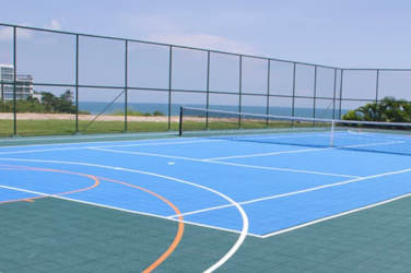 Oceanfront shaded gazebos and palms on sandy beach at Ibiza Beach Residences Panama