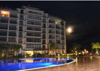 Night view modern condo complex with illuminated pool Ibiza Beach Residences Panama
