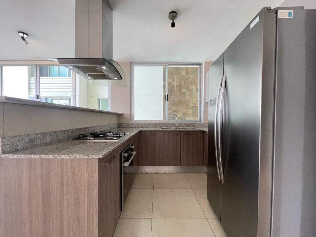 Modern kitchen with granite countertops, stainless steel appliances and wood cabinets in PH Lumiere Costa del Este Panama