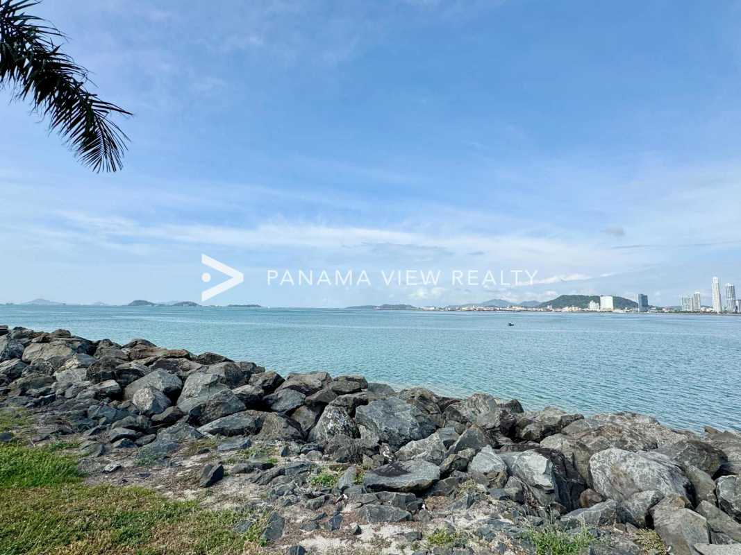 Waterfront rock seawall and Pacific Ocean blue waters with skyline at Ocean Reef Panama City