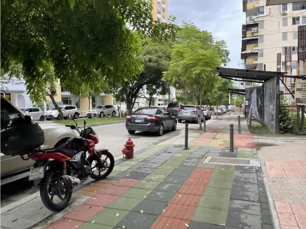 Street view with tiled sidewalk, parked vehicles and PH Entremares El Cangrejo Panama City
