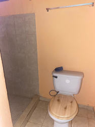 Entrance to tiled bathroom with shower, sink, and toilet in affordable Vacamonte house