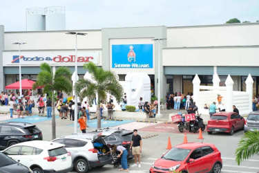 Crowd, stores and parking lot exterior retail plaza in Colon Panama
