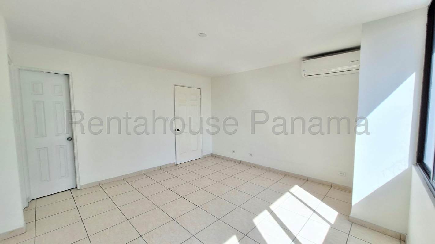 Outdoor pool with sun deck and city buildings PH Coco Mar San Francisco Panama