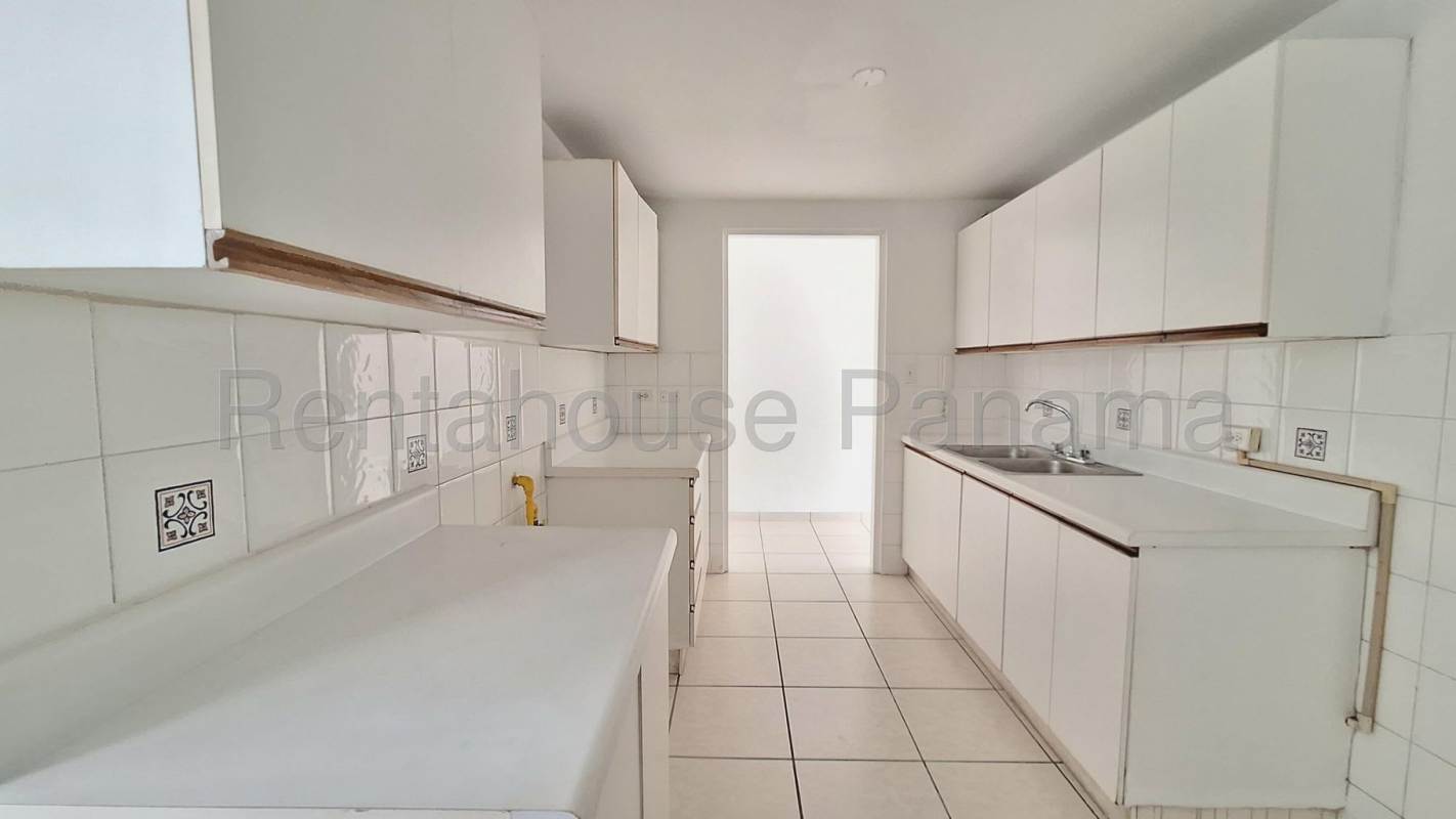 White minimalist galley kitchen with cabinets sink PH Coco Mar San Francisco Panama