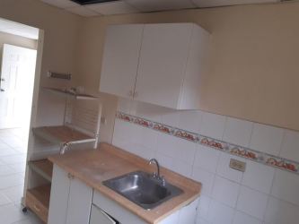 Simple kitchen with wooden countertop and white tiled backsplash Valle Bonito La Chorrera