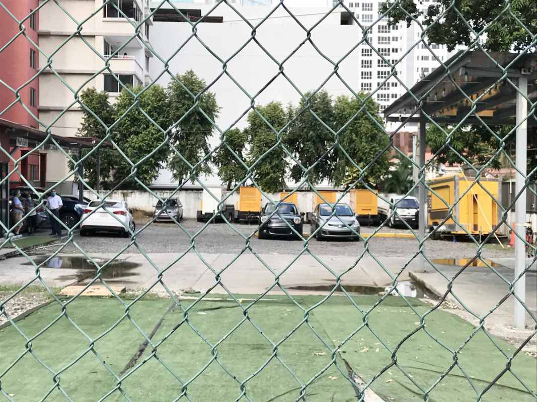 Paved fenced parking area with storage containers on corner lot Coco del Mar Panama City