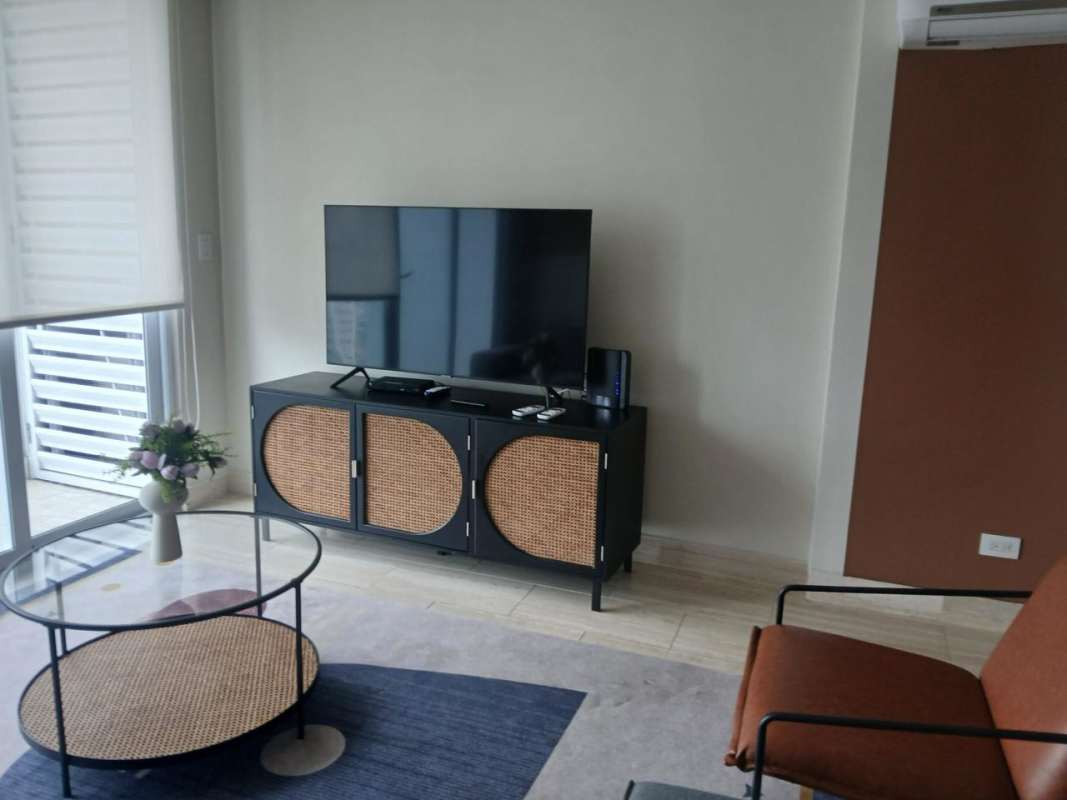 Living room featuring flat screen TV, rattan cabinet, glass coffee table at The Regent Costa del Este Panama
