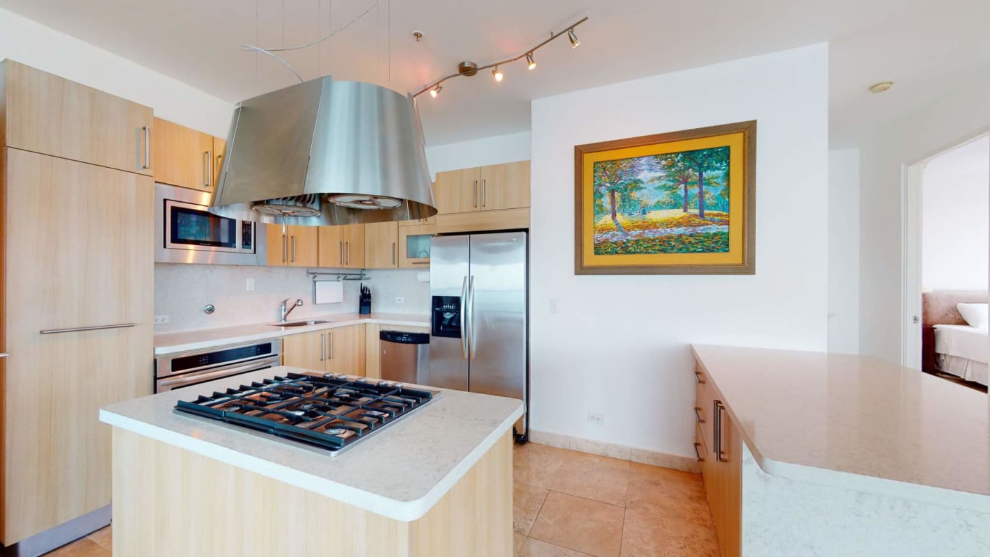 Spacious modern kitchen with granite counters, gas stove, stainless appliances in PH Sky Panama City