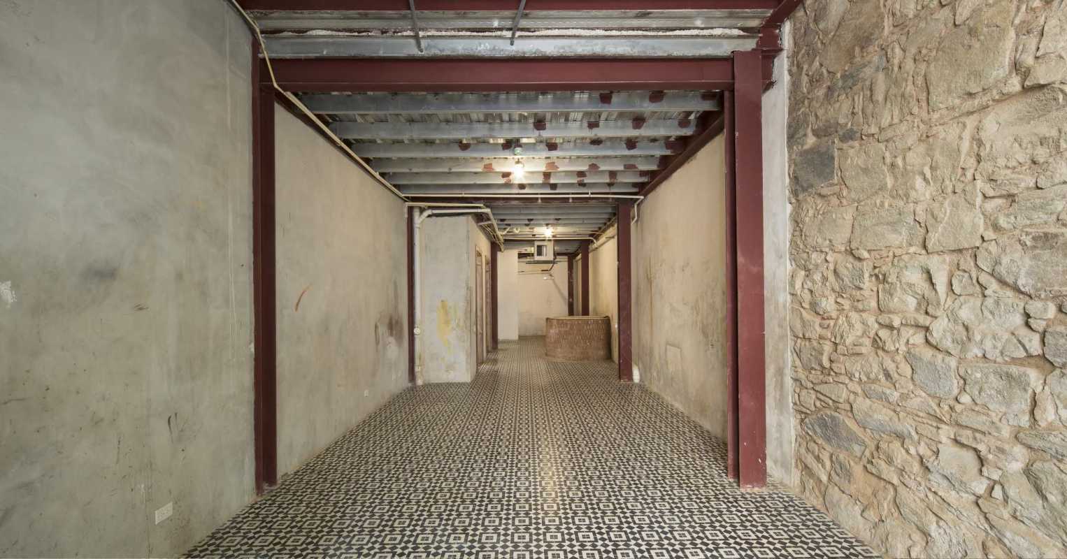 Basement view with exposed metal beams and geometric flooring Casa Banderas Panama
