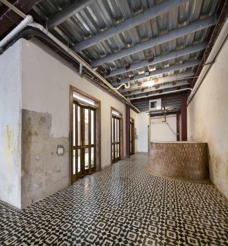 Industrial interior hallway with exposed ceiling, patterned tile floor and brick accents in Casco Viejo Panama