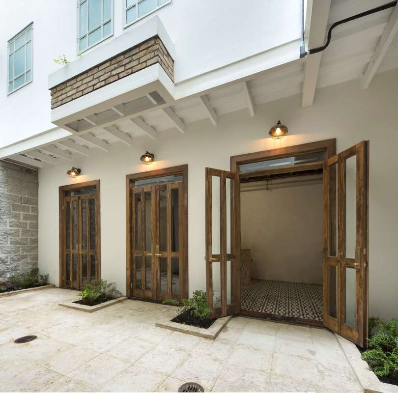 Open-air colonial courtyard with wooden doors and natural stone flooring in Casco Viejo Panama