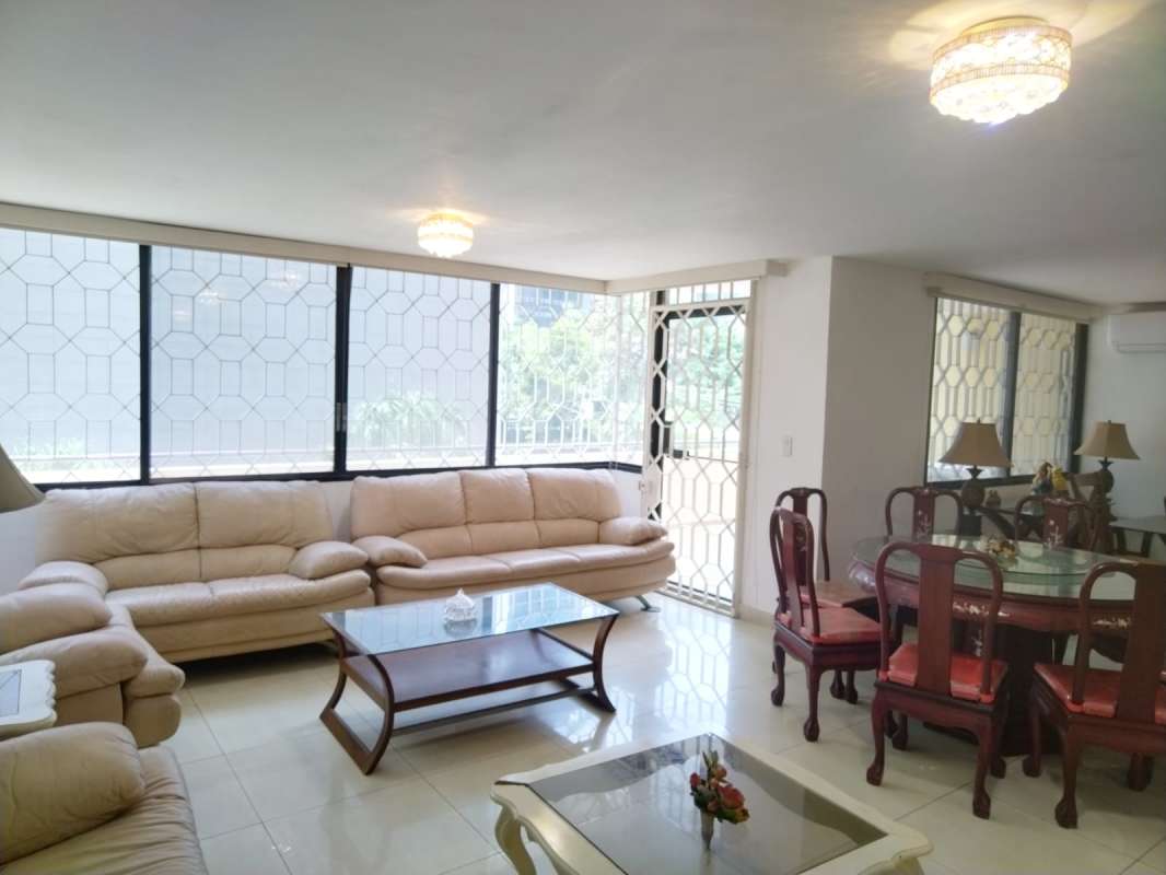 Bright large living and dining room with tiled floor and access to balcony at PH Obarrio Central Panama City