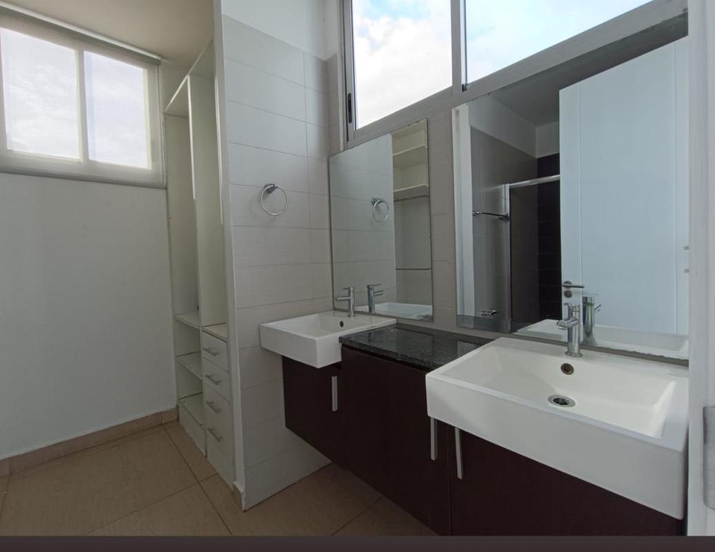 Bathroom with double vanity sinks, mirror and natural light at PH BICSA Panama
