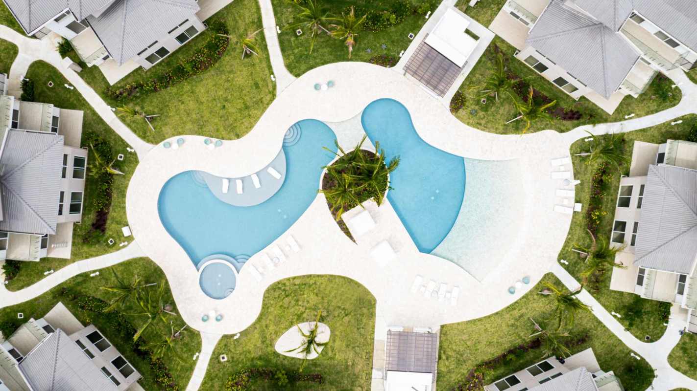 Aerial of resort-style beachfront community pools, Jacuzzis, tropical gardens in Panama