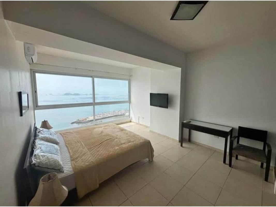 Bedroom with large ocean view window, minimalist decor, AC at PH Miramar Avenida Balboa Panama