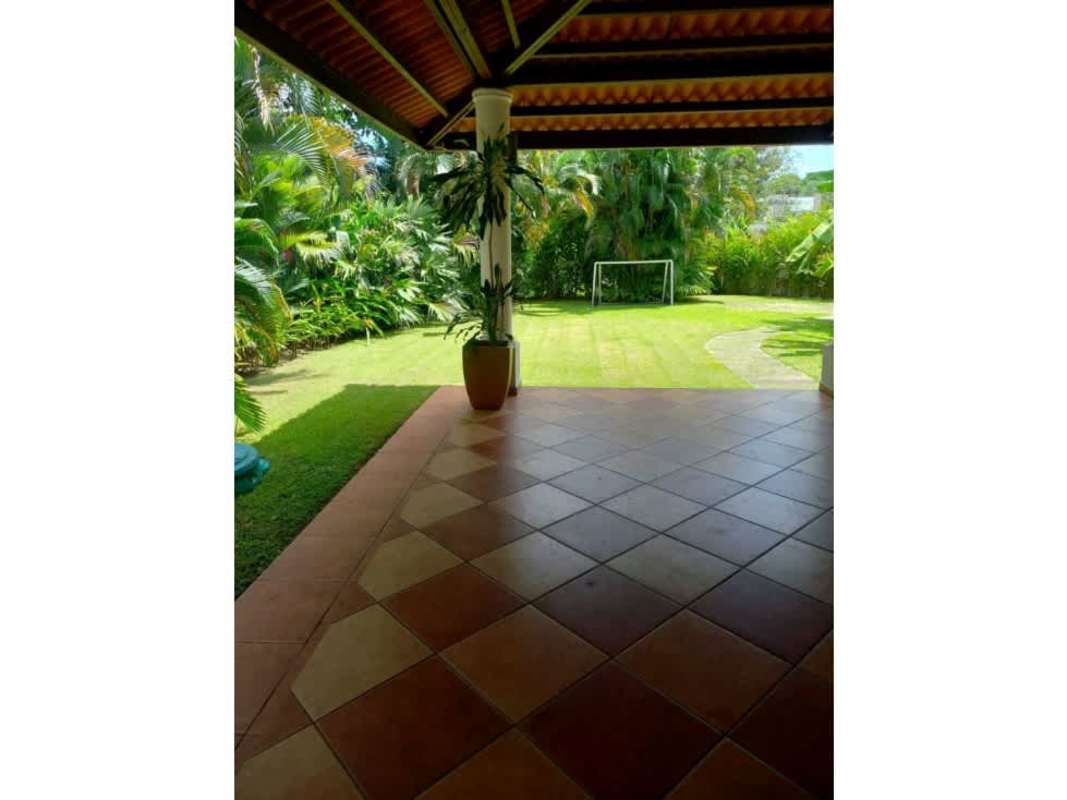 Pass-through archway opens onto kitchen with white cabinets and tiled floor in Ancon rental