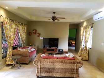Spacious living room with wicker sofas, floral curtains, AC, tropical decor in Coronado luxury villa Panama