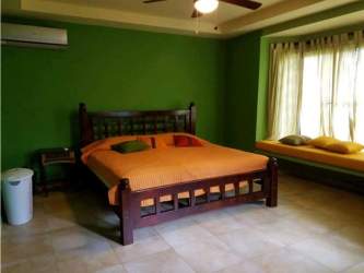 Covered outdoor patio lounge with ceiling fans and hammocks in Mediterranean Coronado villa Panama
