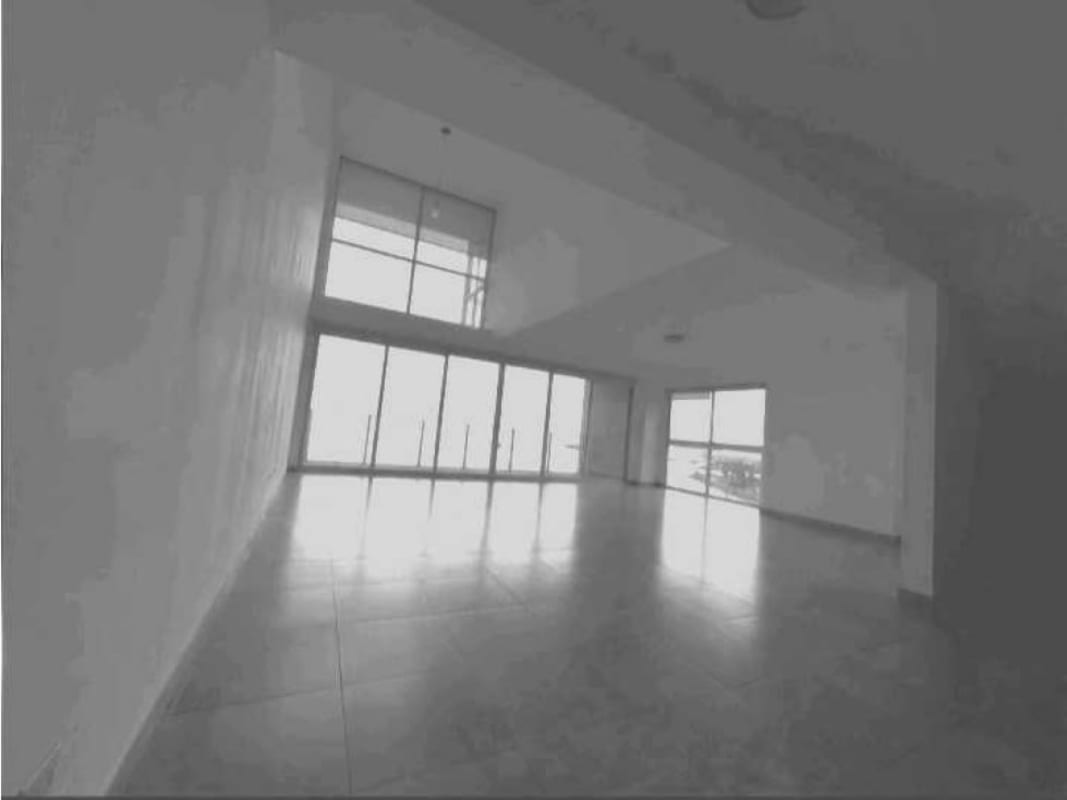 Double height living room with large windows offering ocean and skyline views in PH BICSA Tower Panama