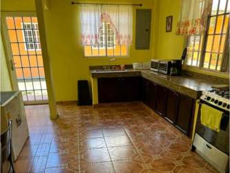 Traditional kitchen with granite countertop, wood cabinets, tiled floors in Rio Hato farm estate property Panama