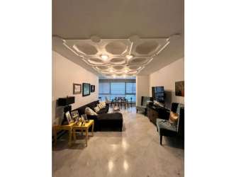 Contemporary dining area with large windows, chandelier, and marble flooring in Punta Paitilla condo