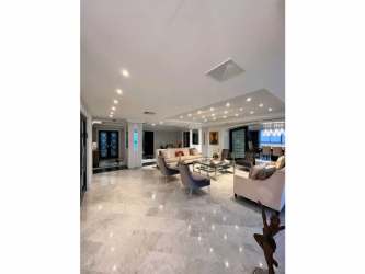 Contemporary kitchen with granite island, pendant lights, stainless appliances, and city views in Punta Paitilla Panama