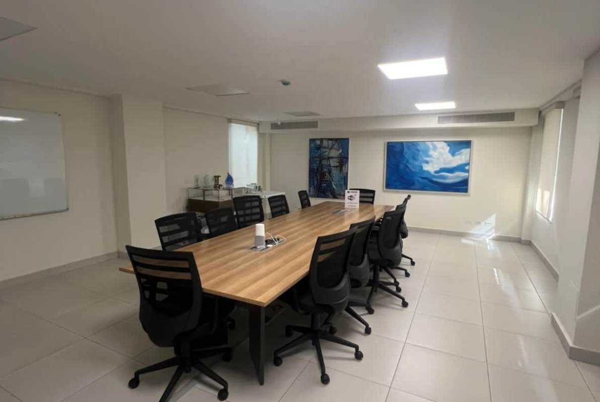 Modern break room dining tables green chairs wall art large window Quarry Heights Panama