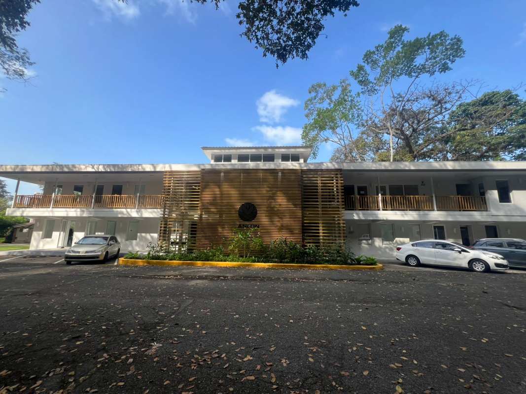 Modern commercial building with wooden accents balconies parking lot at Quarry Heights Business Center in Ancón Panama 