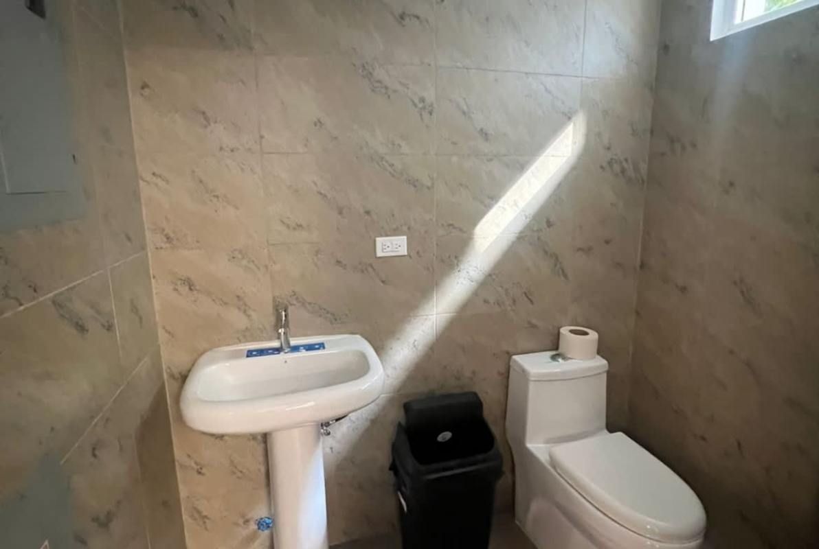Contemporary bathroom with pedestal sink marble tiles and natural light in Quarry Heights Business Center
