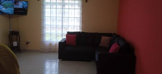 Bright bedroom with two beds, yellow walls, mountain breeze countryside house Chame Panama