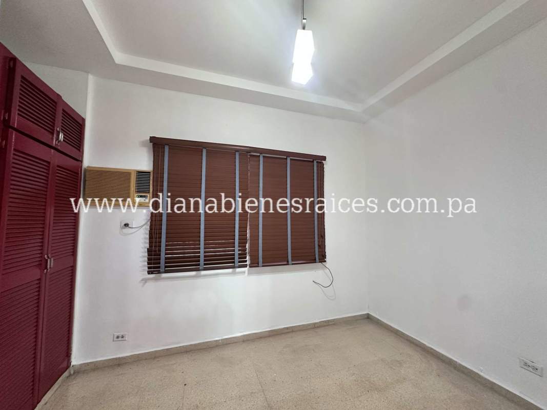 Spacious bedroom with built-in red wardrobe, window blinds, AC in Villas de las Fuentes house Panama City
