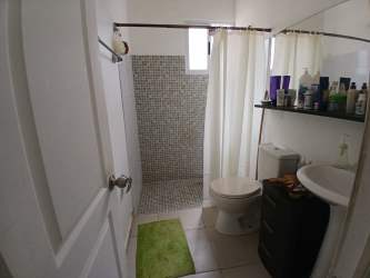 Bright bathroom with mosaic tiled walk-in shower, vanity and window Villas de Arraiján Panama