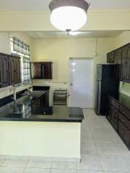 Kitchen in Residencial Howard with appliances, dark cabinets, granite counters