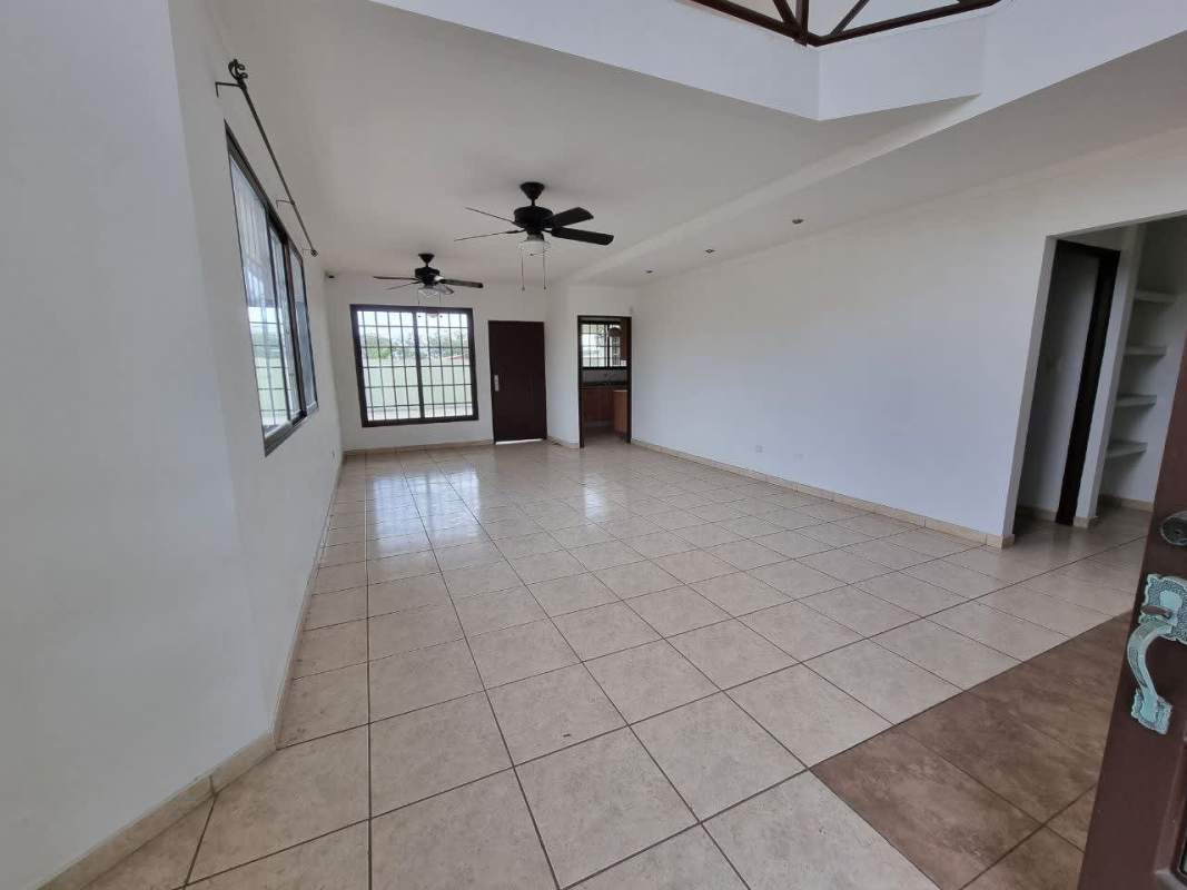Second-story living room with tiled floors balcony access ceiling fans in Brisas del Golf Panama