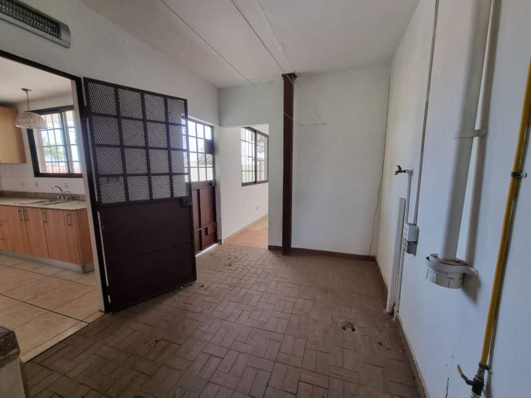 Granite countertop kitchen with dual sink wooden cabinetry tiled walls in house Brisas del Golf Panama City