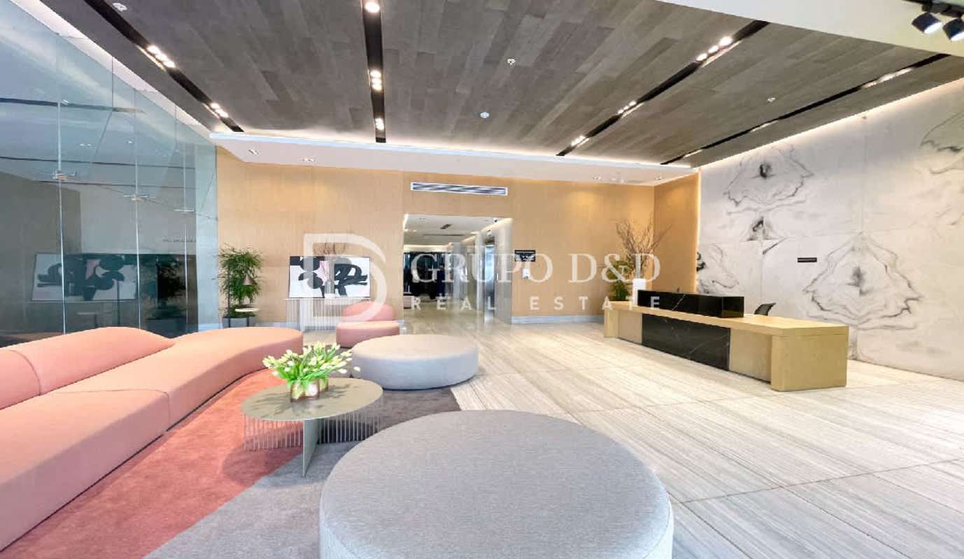 Modern lobby with pink sofa, marble wall, and reception desk Velure Panama