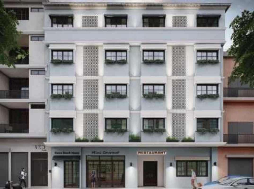 Bright hallway with murals, wooden doors, balcony overlook inside historic hotel in Casco Viejo Panama