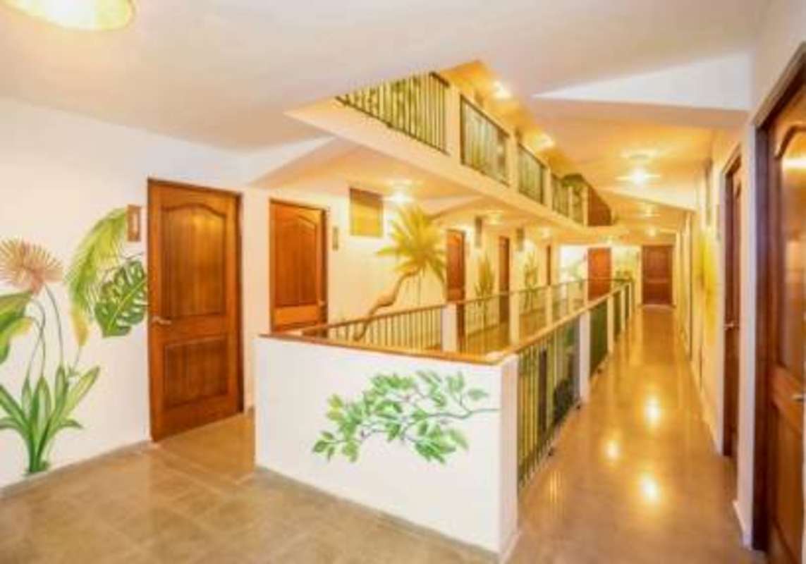 Large guest room with two queen beds, AC, wall mural in boutique hotel Casco Viejo