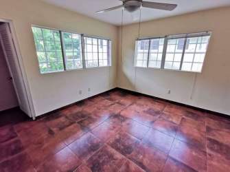Bedroom with bay window, tile floors, ceiling fan in Panama Pacifico Villas de Howard house