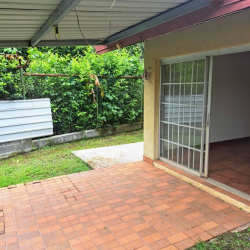 Outdoor covered patio with tile flooring overlooking garden Villas de Howard Panama