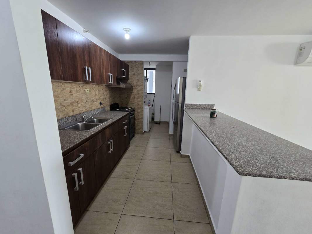 Modern kitchen with granite countertops and wood cabinetry in PH Terrazas del Rey Condado del Rey Panama