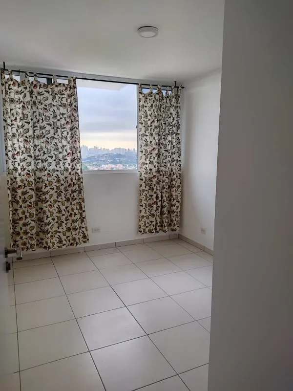 Bedroom with large window blue curtains white tile floor PH El Crisol Panama apartment