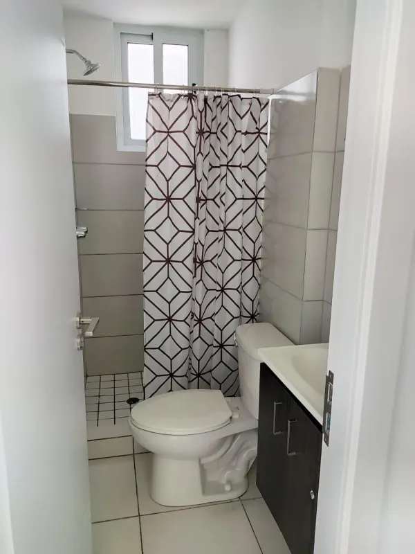 Compact bathroom with shower curtain toilet and vanity PH El Crisol Panama