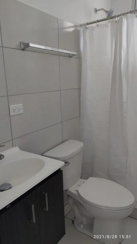 Bathroom with tiled walls vanity mirror shower curtain PH El Crisol Tower Panama